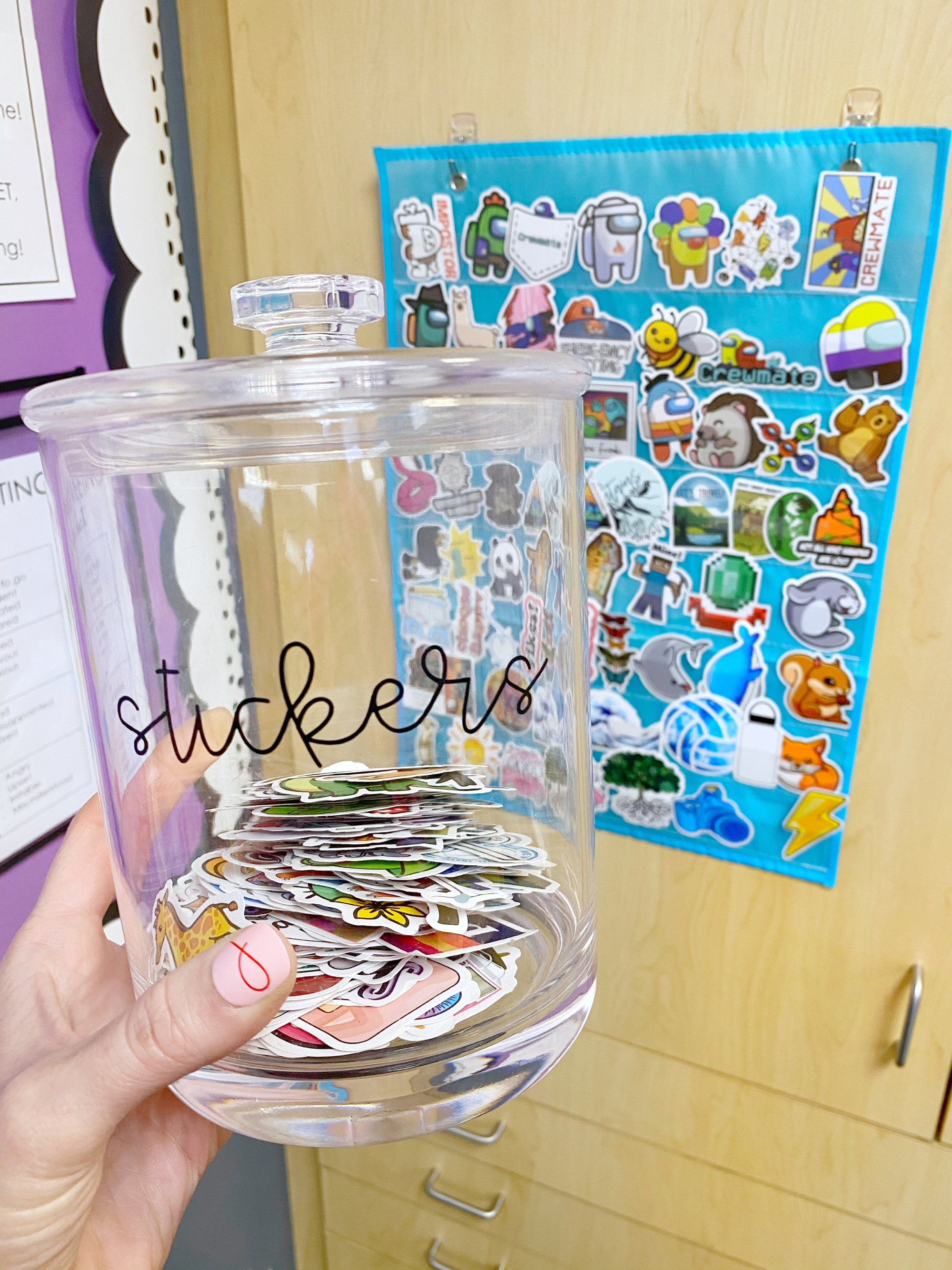 This clear plastic jar is perfect for storing stickers in your classroom! Then add them to a pocket chart for an easy sticker display that students can browse to pick out a sticker!